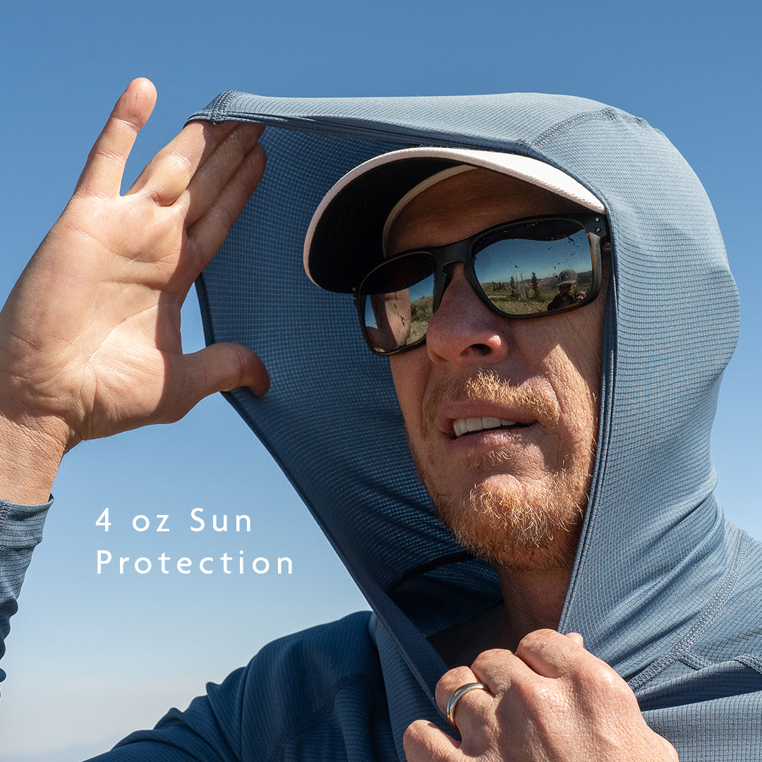 Blue - A man outdoors wearing a sun hoodie with the hood pulled up