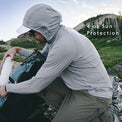 Gray - man on mountain top wearing sun shirt and adjusting gear in backpack