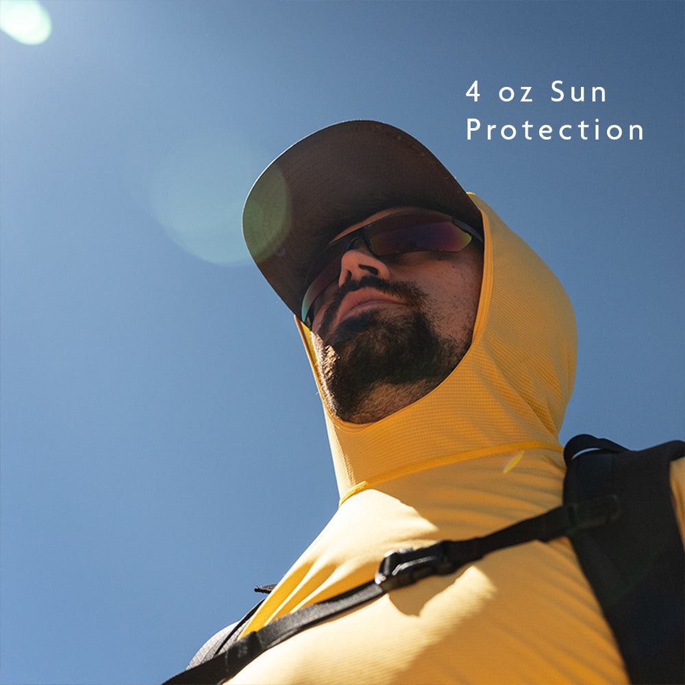 Man wearing a yellow sun hoodie against a blue sky