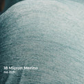 Close-up of textured wool fabric with white text reading '18 Micron Merino no itch.'