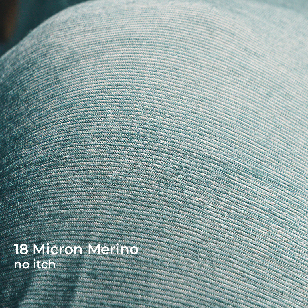 Close-up of textured wool fabric with white text reading '18 Micron Merino no itch.'