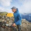 side view of man wearing blue Vario Jacket on mountain peak