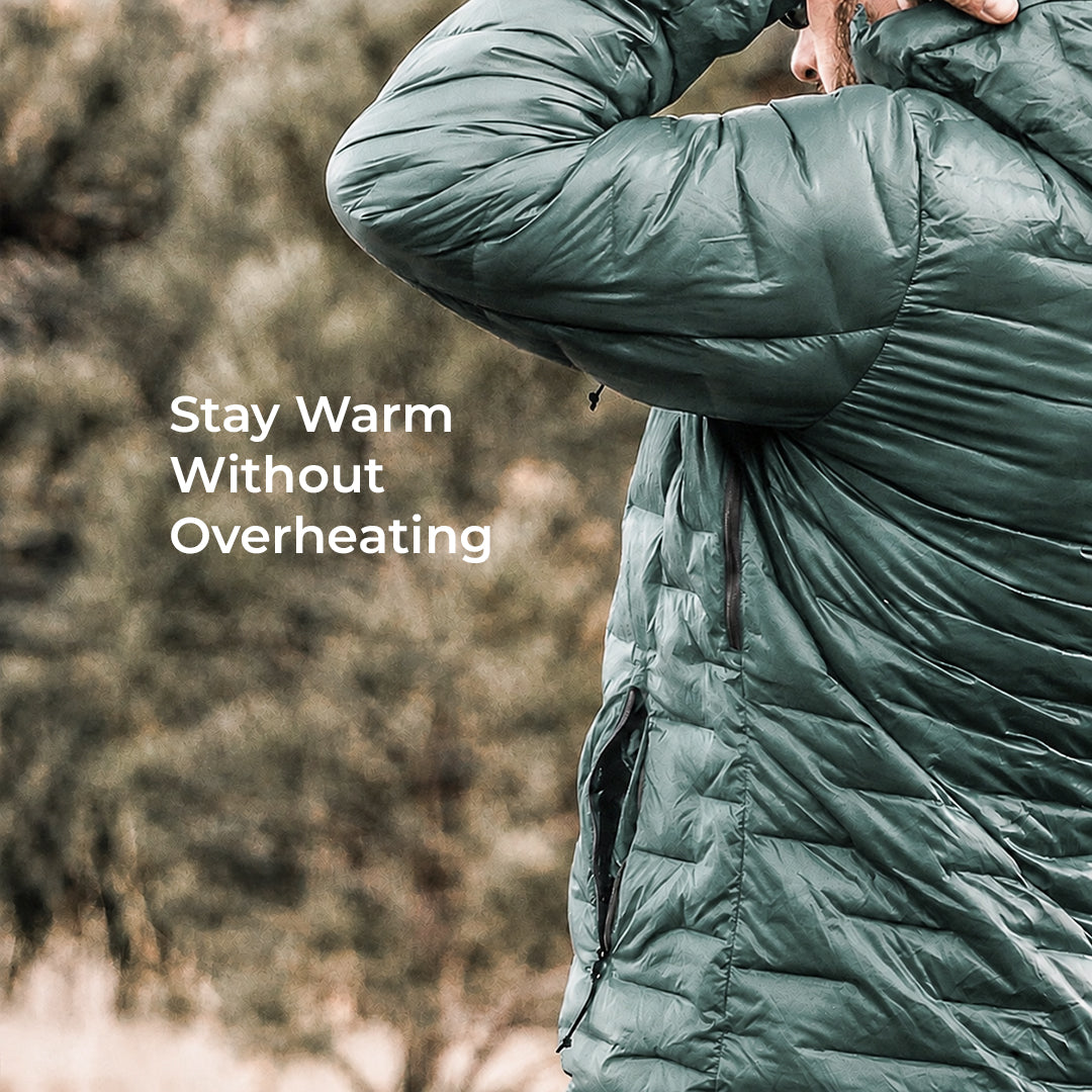 A person wearing a dark green quilted puffer jacket, shown from the back and side, with the text 'Stay Warm Without Overheating' overlaid on the left against a blurred outdoor background.