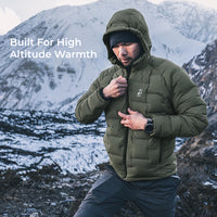 man wearing warm green puffy down jacket in high mountain conditions