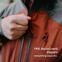 Close-up of a person wearing a waterproof rain jacket and pulling the YKK zipper, with water droplets on the fabric. White text reads 'YKK AquaGuard Zippers everything stays dry'.