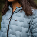 Close-up of women’s insulated down jacket showing logo and quilted baffle pattern.
