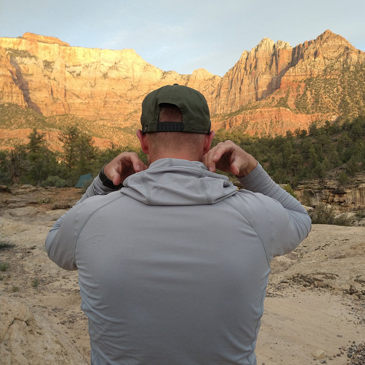 Gray - Man wearing the Altitude Sun Hoodie in front of the mountain