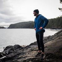 male runner wearing Ventus mid layer pausing by river to catch his breath