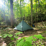 front view of single person trekking pole tent in a forest