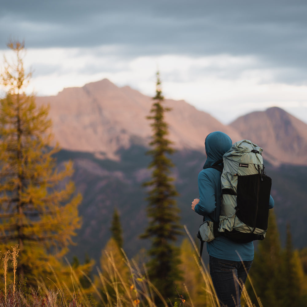Hiker wearing the Shadowlight Ultralight Backpack with a mountainous backdrop