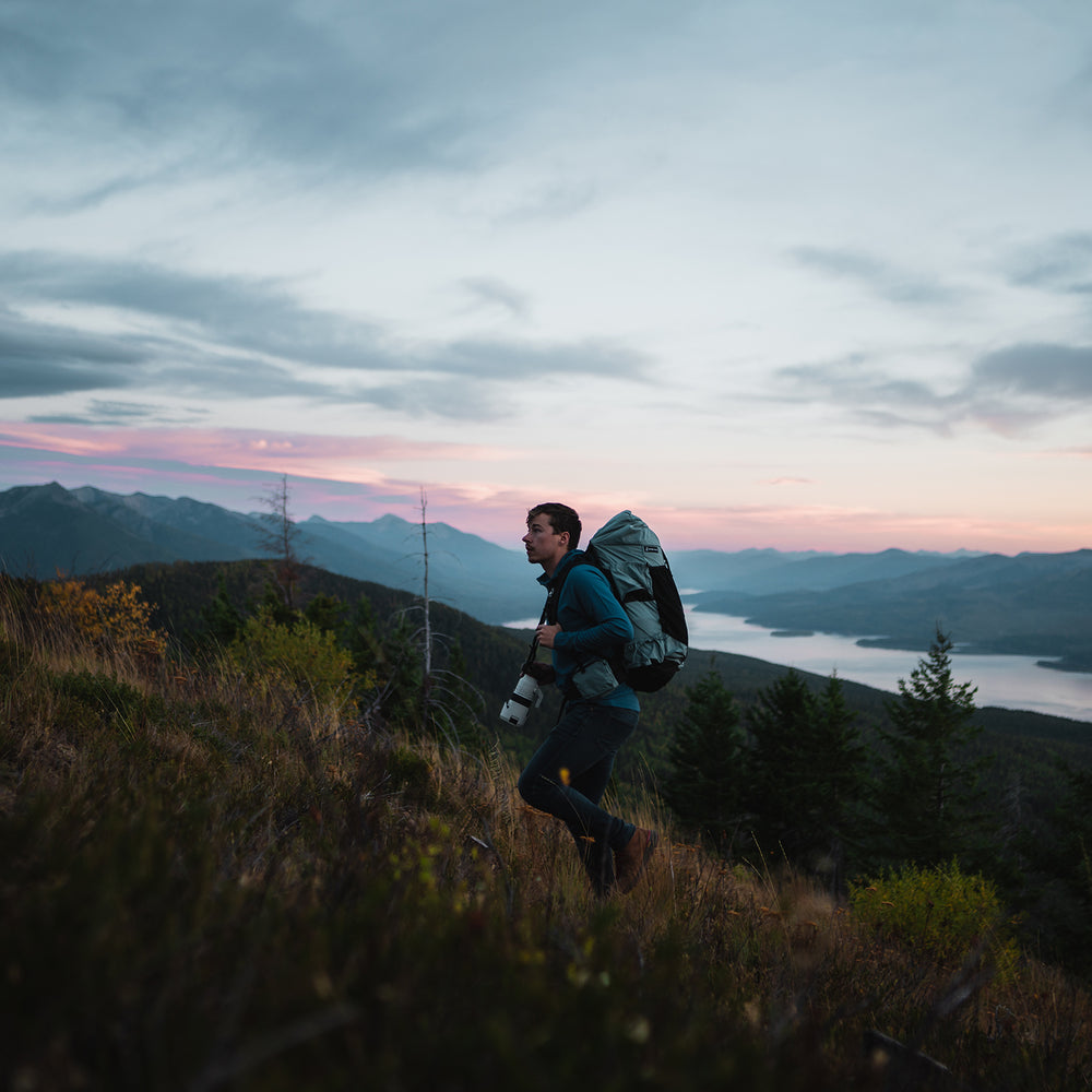 Individual trekking up a hill with the Shadowlight Ultralight Backpack