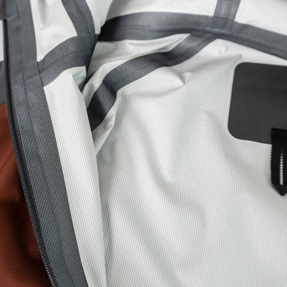 close view of seam taping inside men's ultralight rain jacket for backpacking