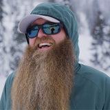 man smiles while wearing windbreaker jacket in snow